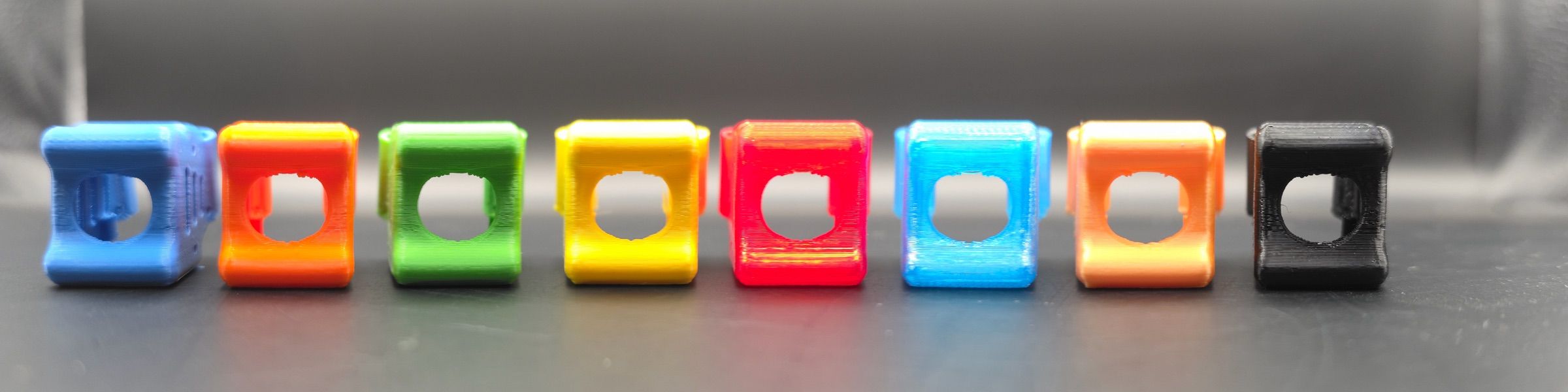 Osm TPU klecí kamery pro rám Minibyte 2.5 v řadě — modrá, oranžová, zelená, žlutá, červená, světle modrá, oranžová a černá barevná varianta.